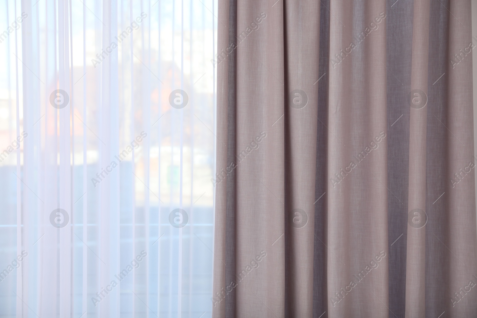 Photo of Window with elegant curtains indoors, closeup view