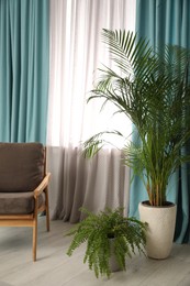 Photo of Comfortable armchair near window with elegant curtains in room