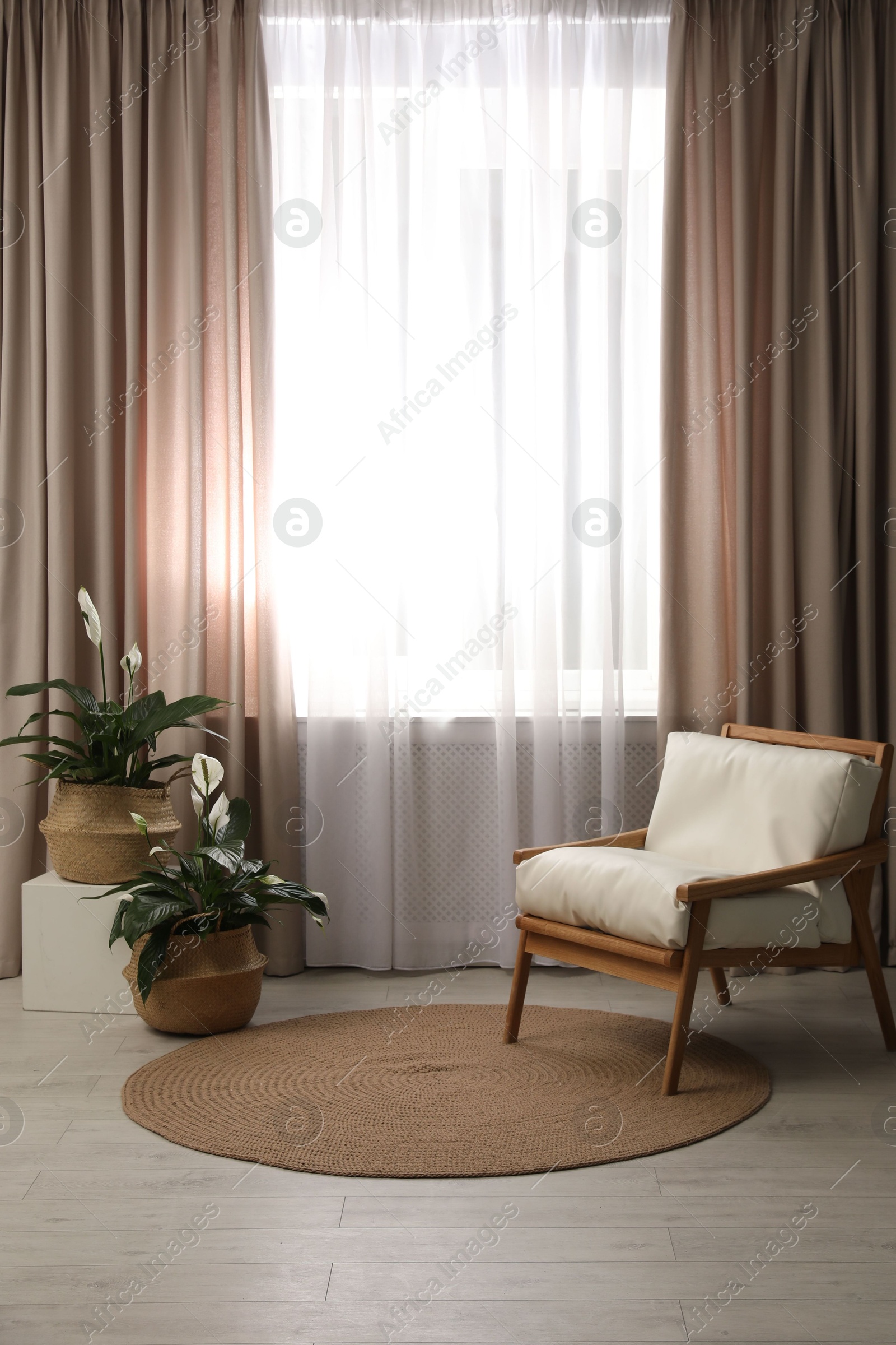 Photo of Comfortable armchair near window with elegant curtains in room