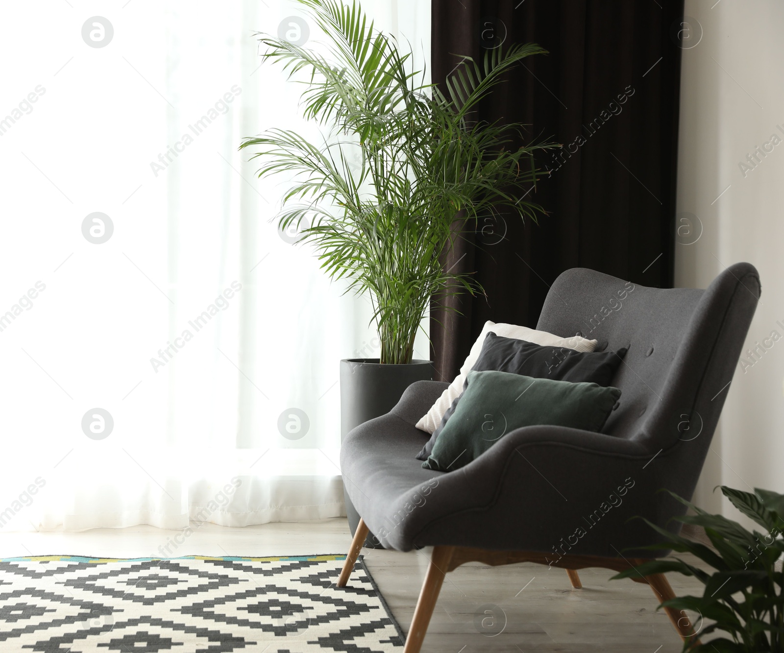 Comfortable sofa near window with elegant curtains in room. Space for text Photo of Comfortable sofa near window with elegant curtains in room. Space for text