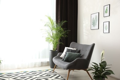 Photo of Comfortable sofa near window with elegant curtains in room. Space for text