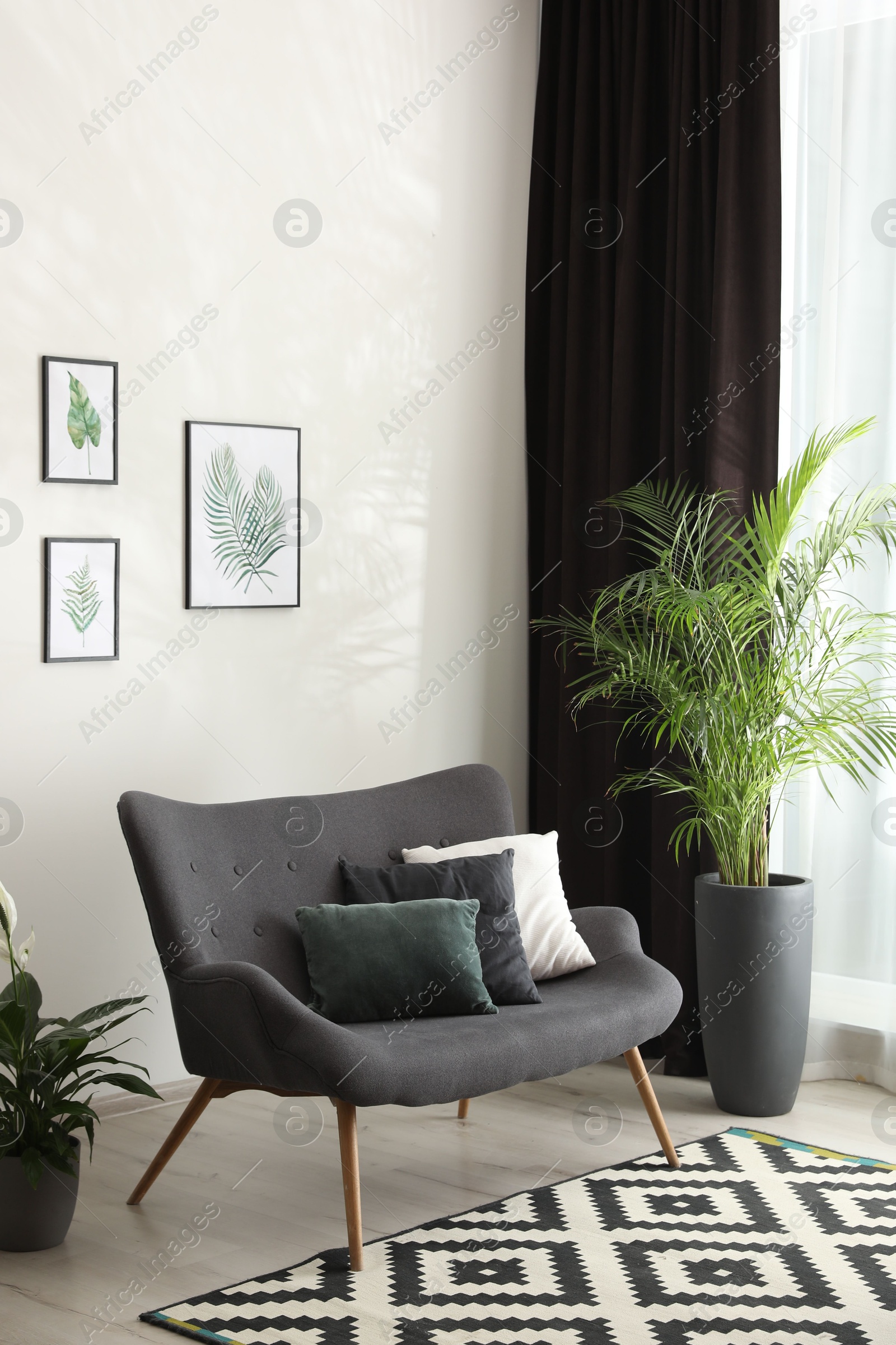 Photo of Comfortable sofa near window with elegant curtains in room