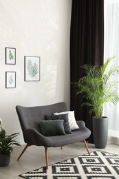 Photo of Comfortable sofa near window with elegant curtains in room