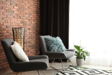 Photo of Comfortable chairs near window with elegant curtains in room
