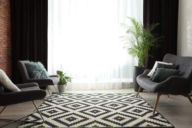 Photo of Comfortable sofa and chairs near window with elegant curtains in room