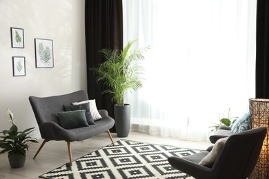 Photo of Comfortable sofa near window with elegant curtains in room