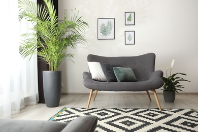 Photo of Comfortable sofa near window with elegant curtains in room