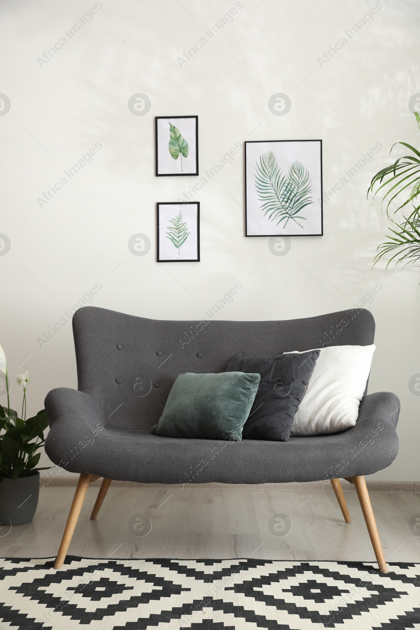 Comfortable sofa near white wall in room Photo of Comfortable sofa near white wall in room