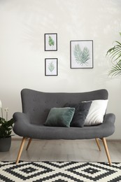 Photo of Comfortable sofa near white wall in room