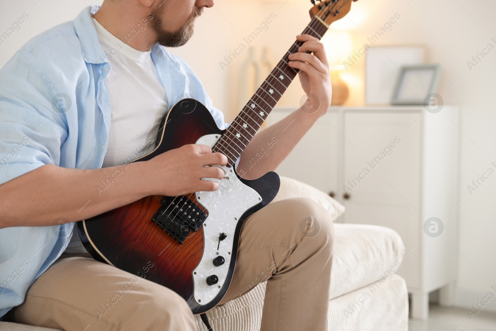 Man playing electric guitar at home, closeup Photo of Man playing electric guitar at home, closeup