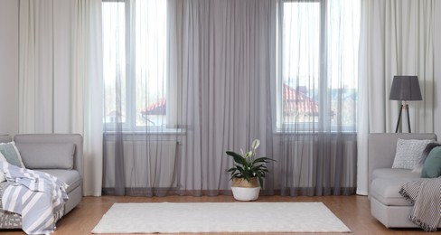 Photo of Windows with stylish curtains in living room interior