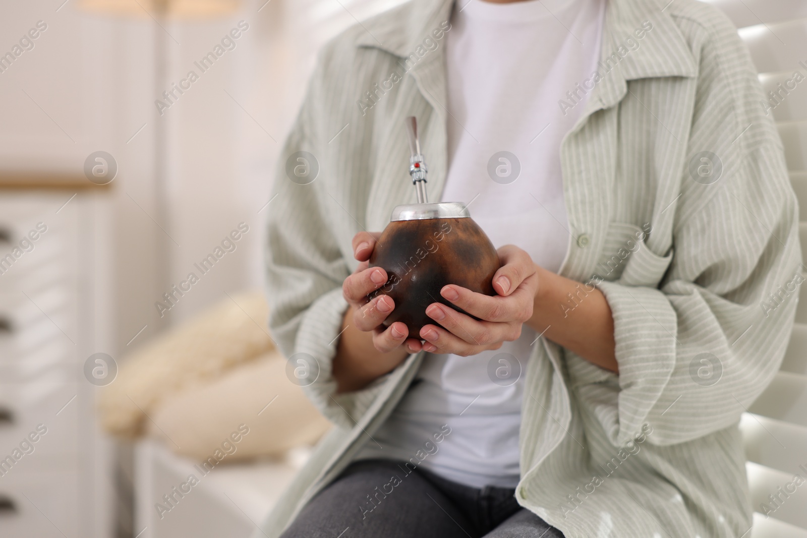 Woman drinking traditional yerba mate tea indoors, closeup Photo of Woman drinking traditional yerba mate tea indoors, closeup