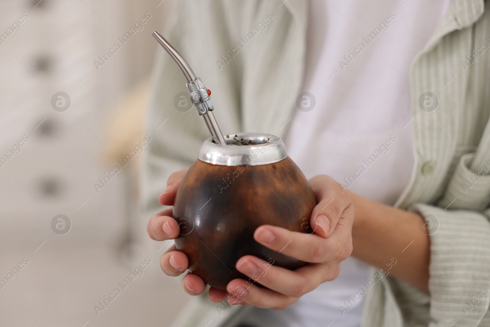 Woman drinking traditional yerba mate tea indoors, closeup Photo of Woman drinking traditional yerba mate tea indoors, closeup