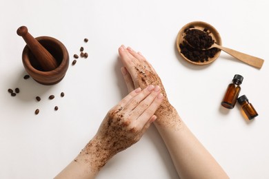 Photo of Woman applying body scrub onto her hand on white background, top view