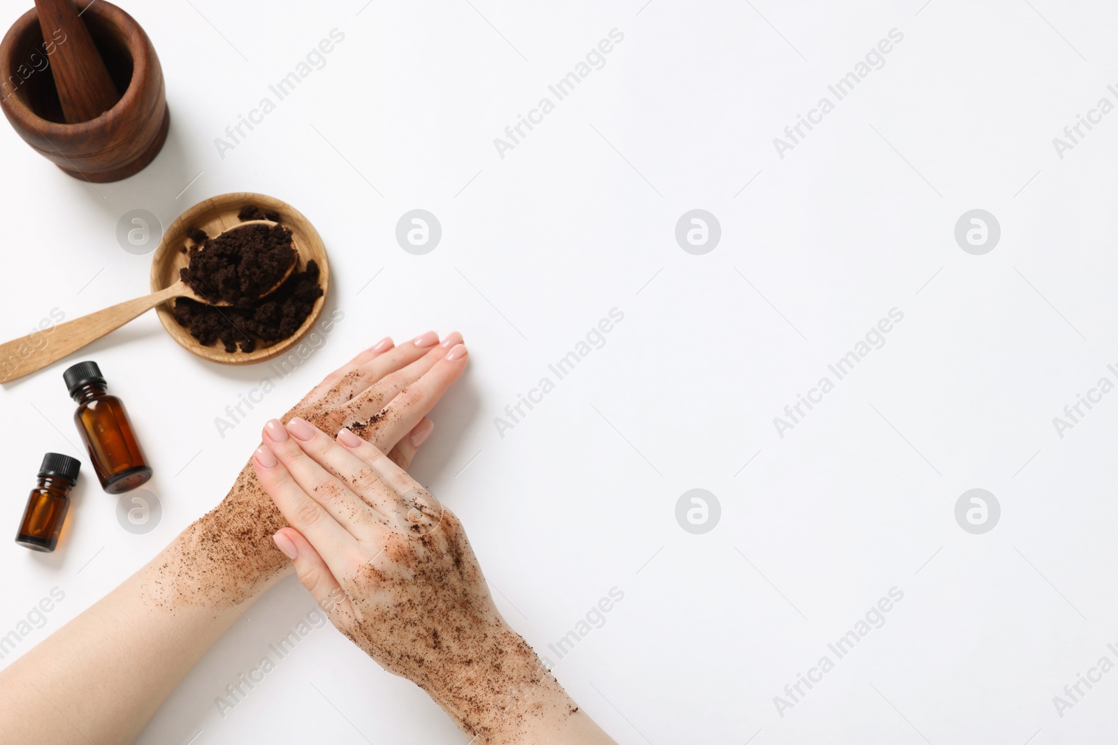 Woman applying body scrub onto her hand on white background, top view. Space for text Photo of Woman applying body scrub onto her hand on white background, top view. Space for text
