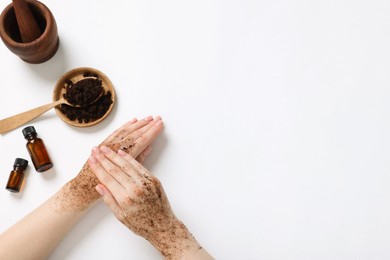 Photo of Woman applying body scrub onto her hand on white background, top view. Space for text