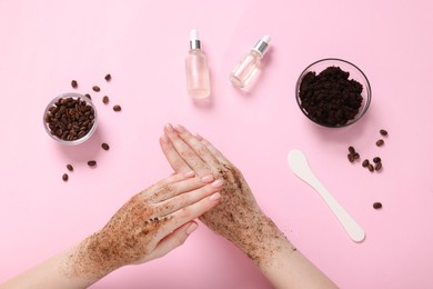 Photo of Woman applying body scrub onto her hand on pink background, top view