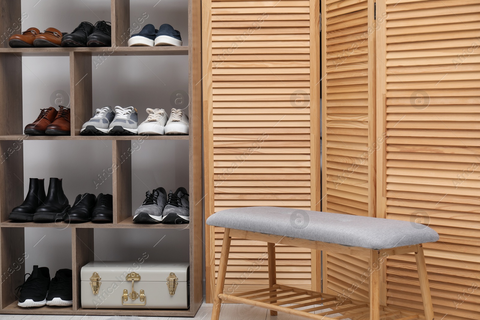 Shoe storage. Shelving unit with different footwear, folding screen and bench indoors Photo of Shoe storage. Shelving unit with different footwear, folding screen and bench indoors