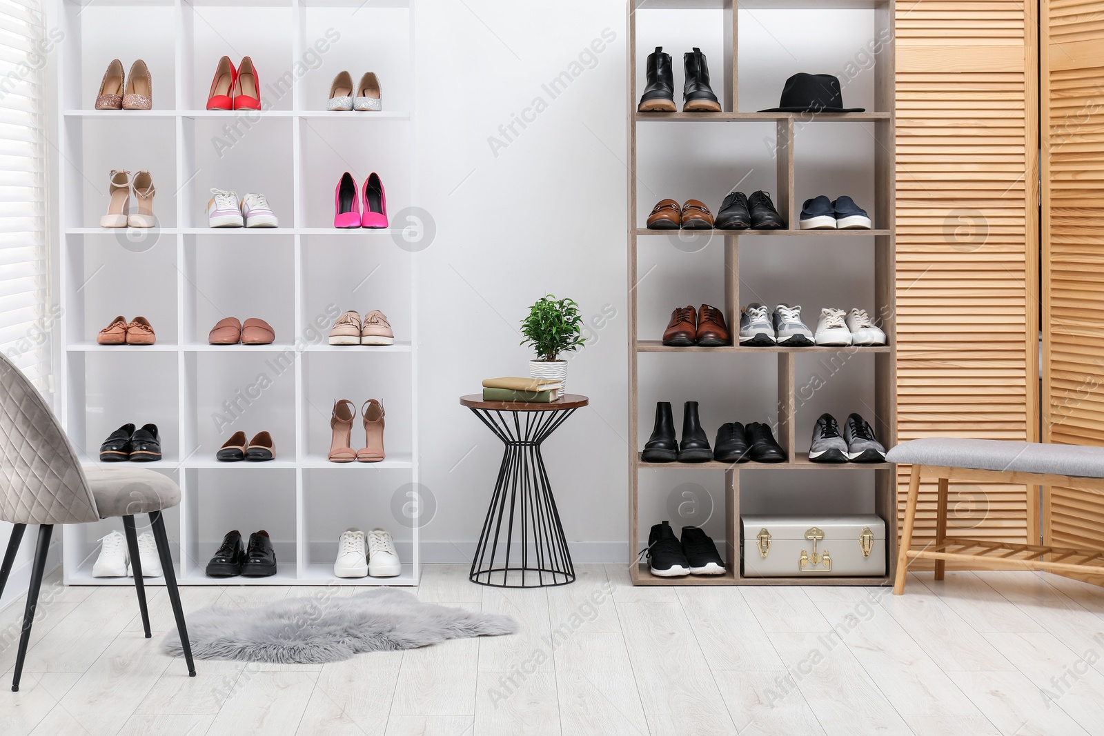 Shoe storage. Shelving units with different footwear, chair, bench and side table indoors Photo of Shoe storage. Shelving units with different footwear, chair, bench and side table indoors