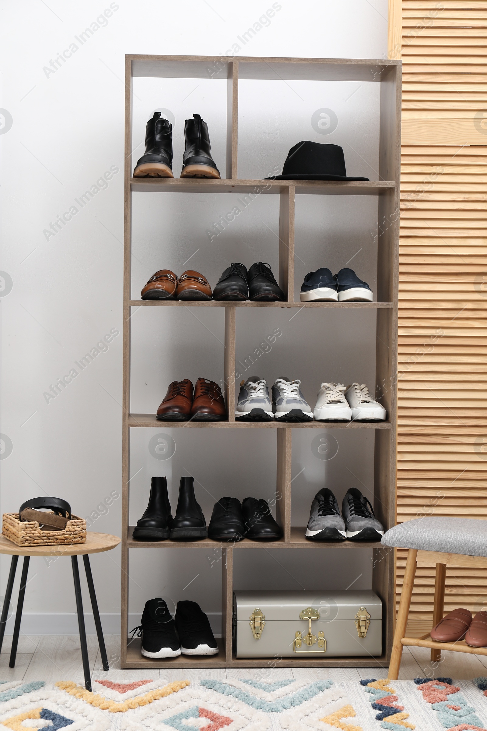 Photo of Shoe storage. Shelving unit with different footwear and accessories indoors