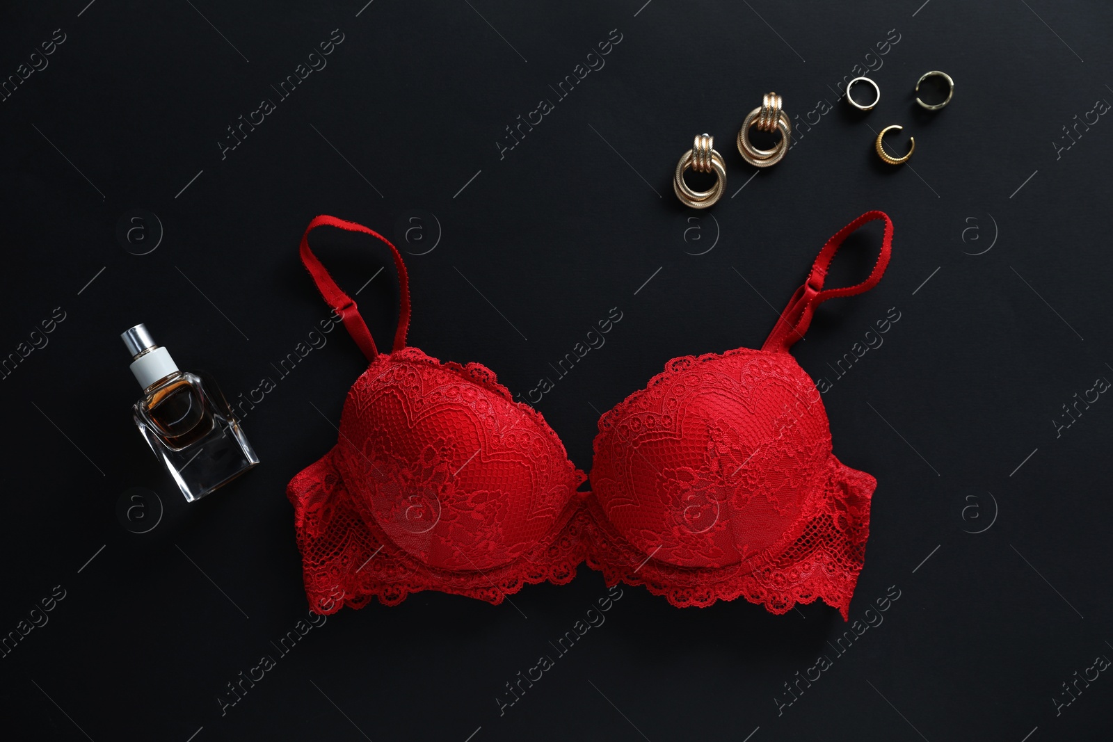 Red bra, jewelry and perfume on black background, flat lay Photo of Red bra, jewelry and perfume on black background, flat lay