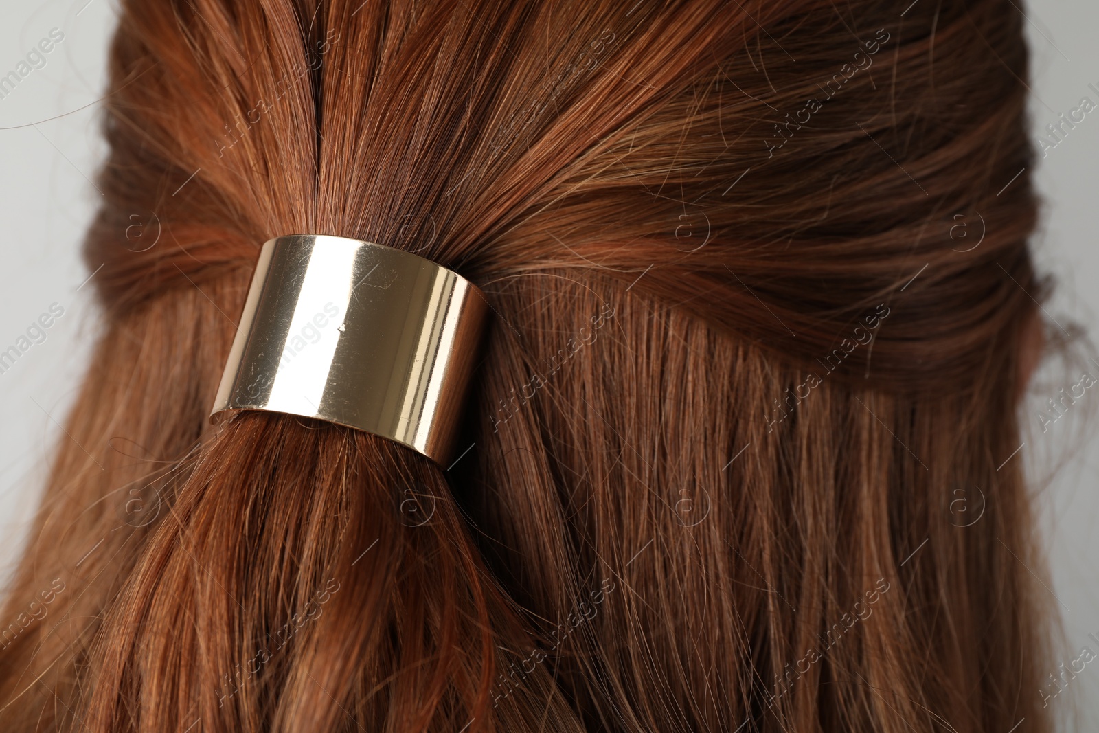 Woman with beautiful hair tie on light grey background, back view Photo of Woman with beautiful hair tie on light grey background, back view