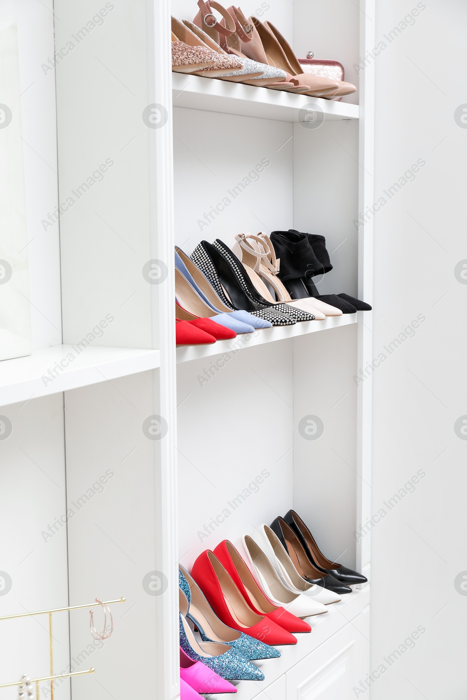 Shoe storage. Different high heeled shoes on shelves indoors Photo of Shoe storage. Different high heeled shoes on shelves indoors