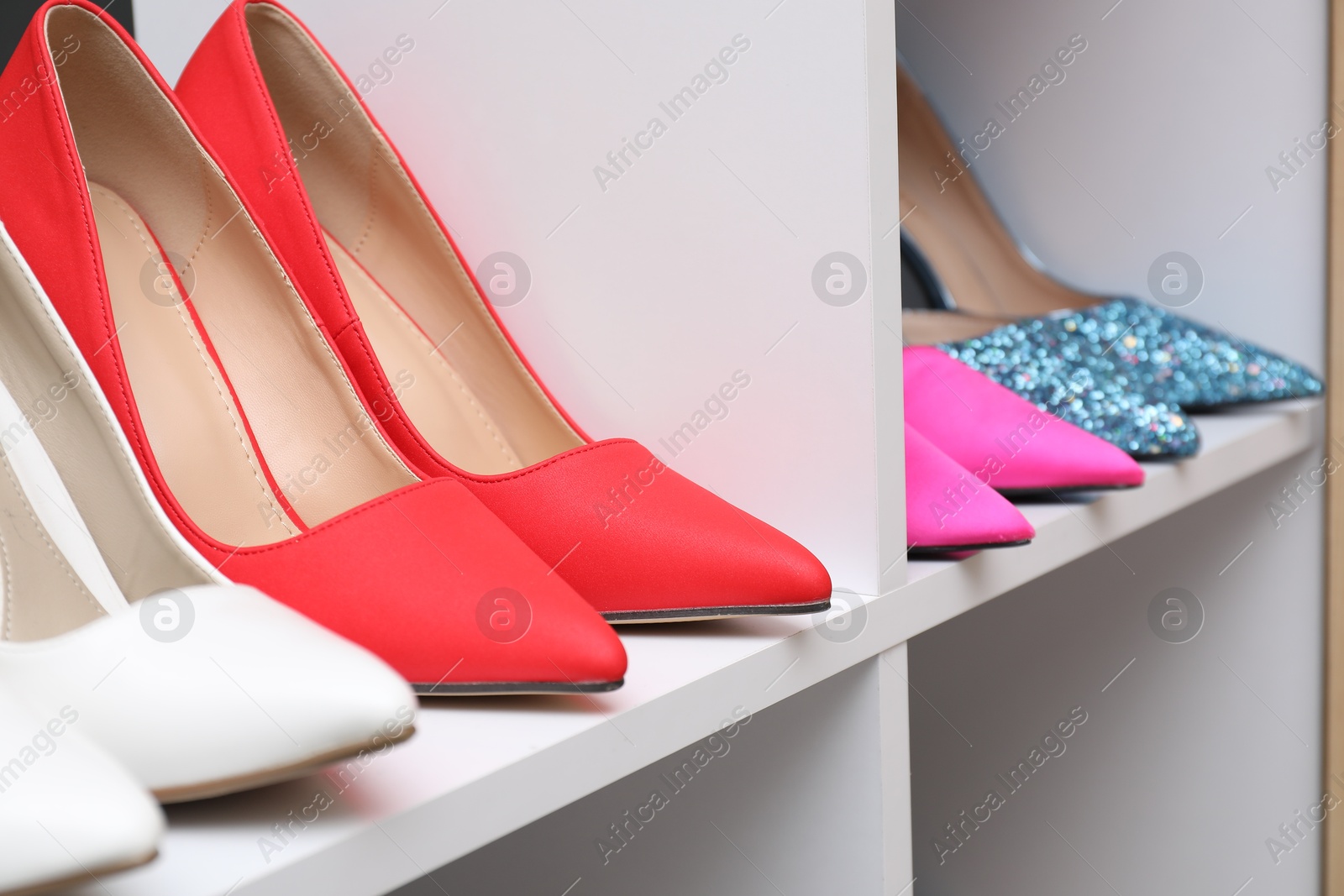 Shoe storage. Different high heeled shoes on shelves indoors, closeup Photo of Shoe storage. Different high heeled shoes on shelves indoors, closeup