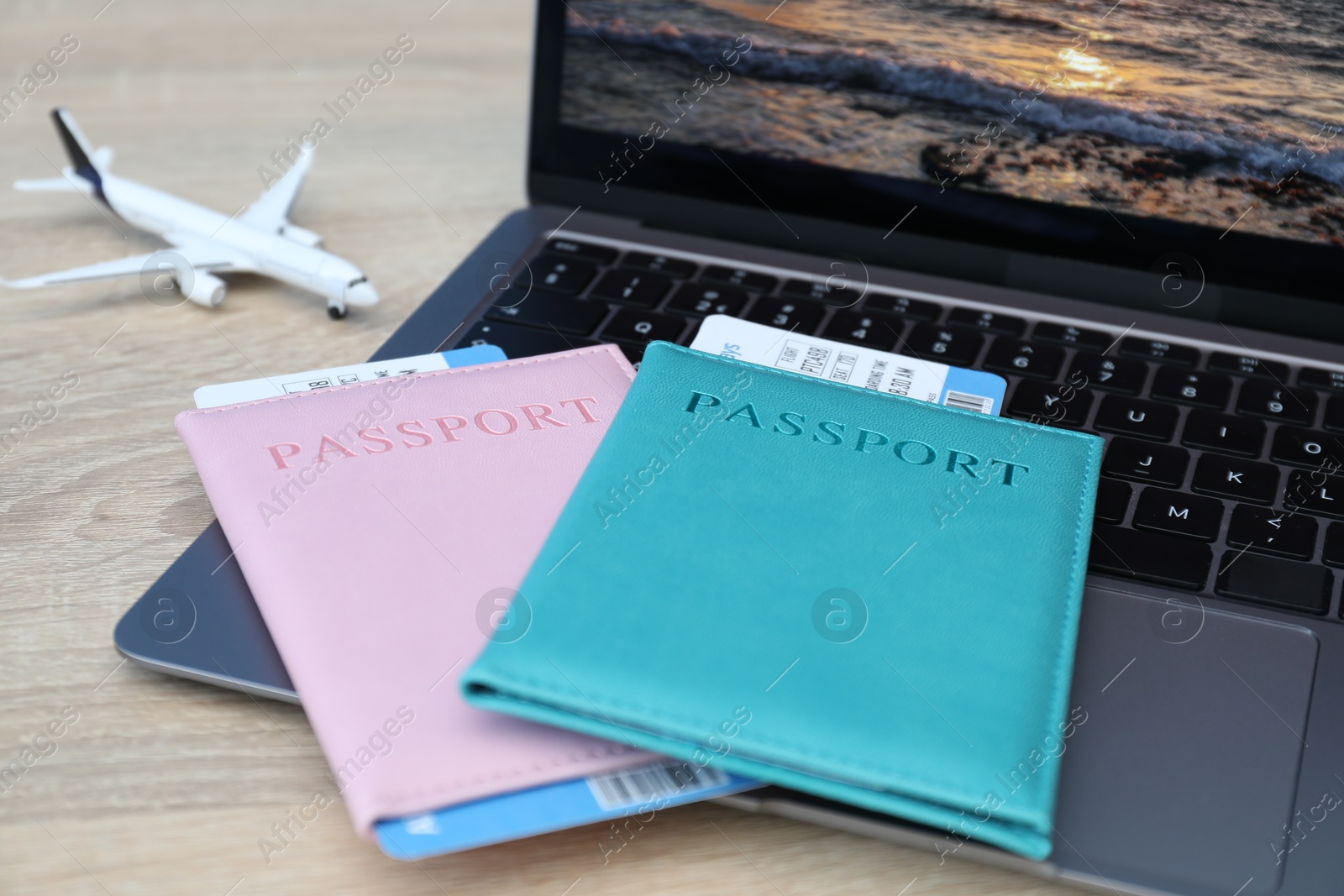 Passports, flight tickets, plane model and laptop on wooden table, closeup Photo of Passports, flight tickets, plane model and laptop on wooden table, closeup