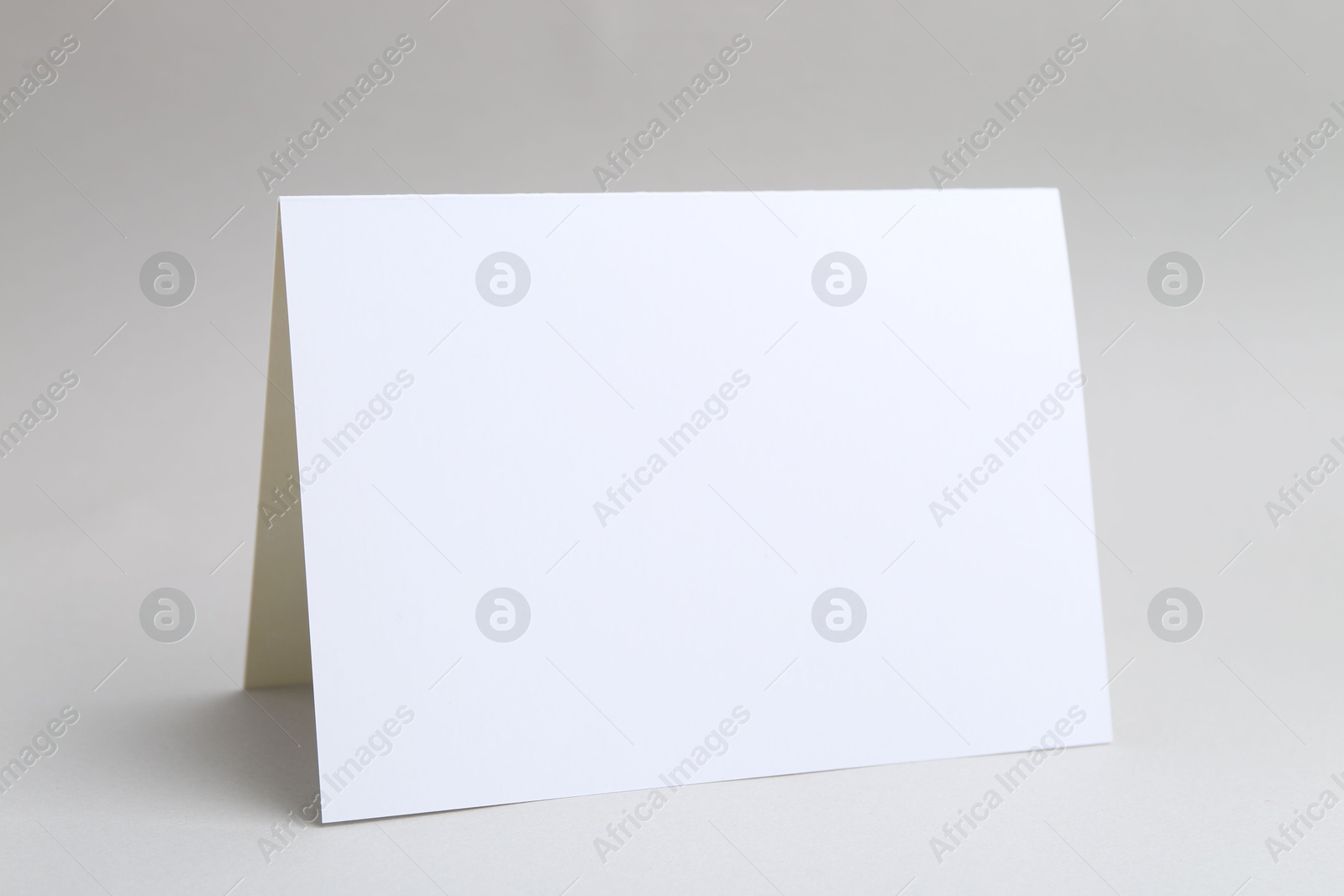 Photo of One blank greeting card on light background