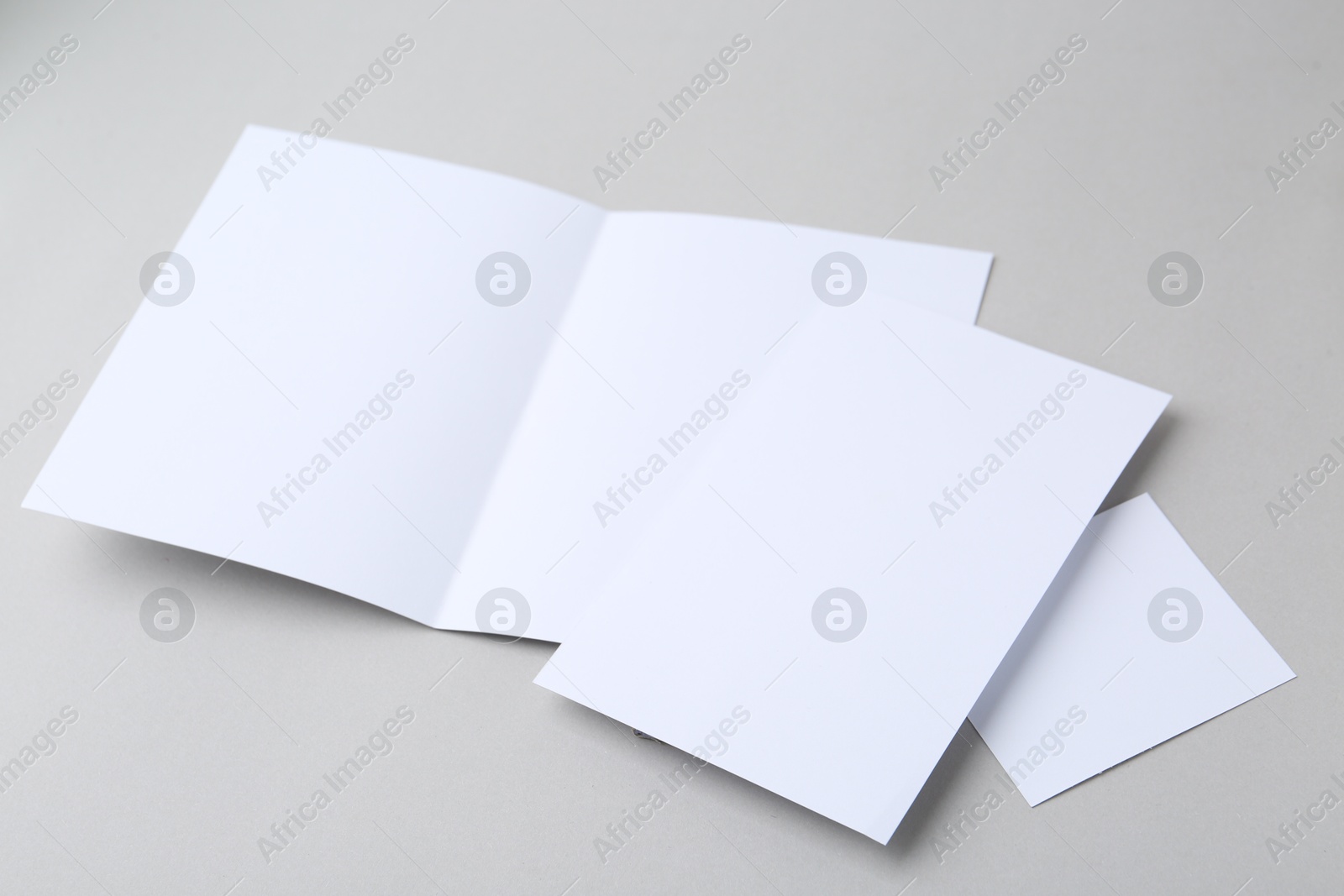 Photo of Blank greeting cards on light background, closeup