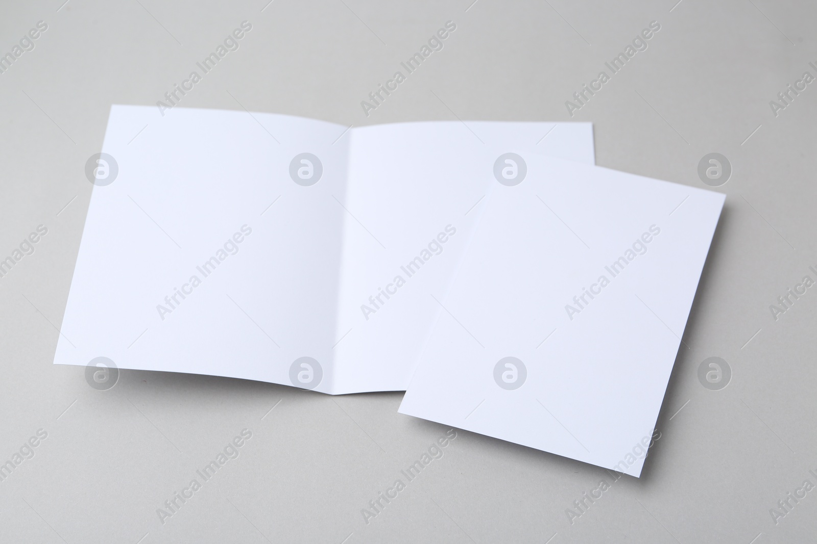 Photo of Blank greeting cards on light background, closeup