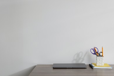 Photo of Laptop and different stationery on wooden office table against white background, space for text