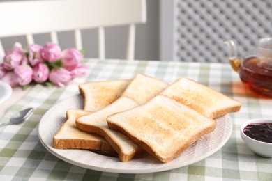 Photo of Tasty crispy toasted bread slices on table