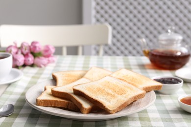 Photo of Tasty crispy toasted bread slices on table