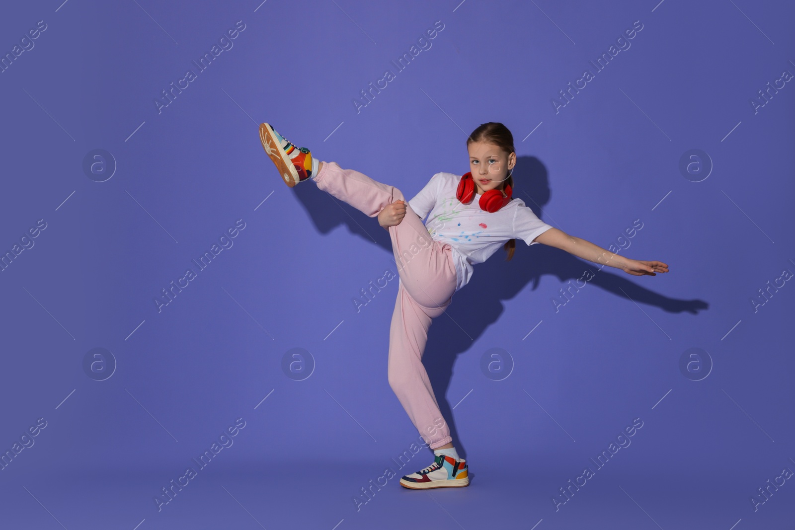 Photo of Girl with headphones dancing on purple background