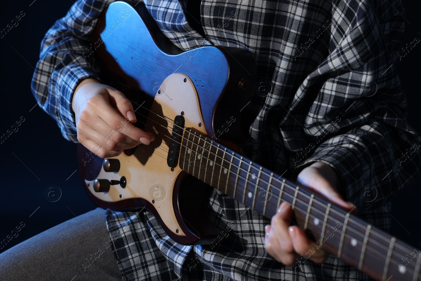 Woman playing guitar on black background, closeup Photo of Woman playing guitar on black background, closeup