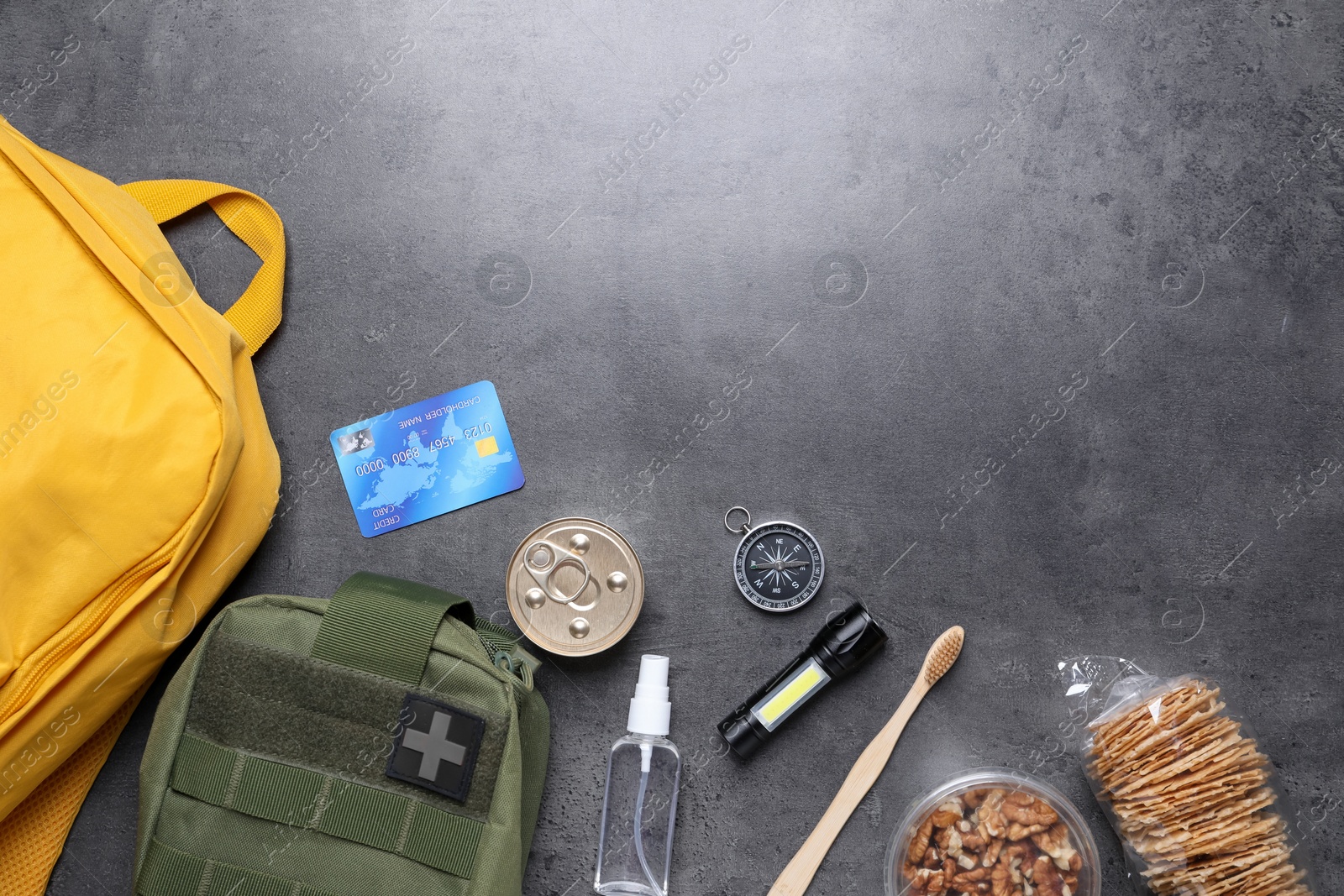 Survival kit. Different emergency supplies on grey table, flat lay. Space for text Photo of Survival kit. Different emergency supplies on grey table, flat lay. Space for text