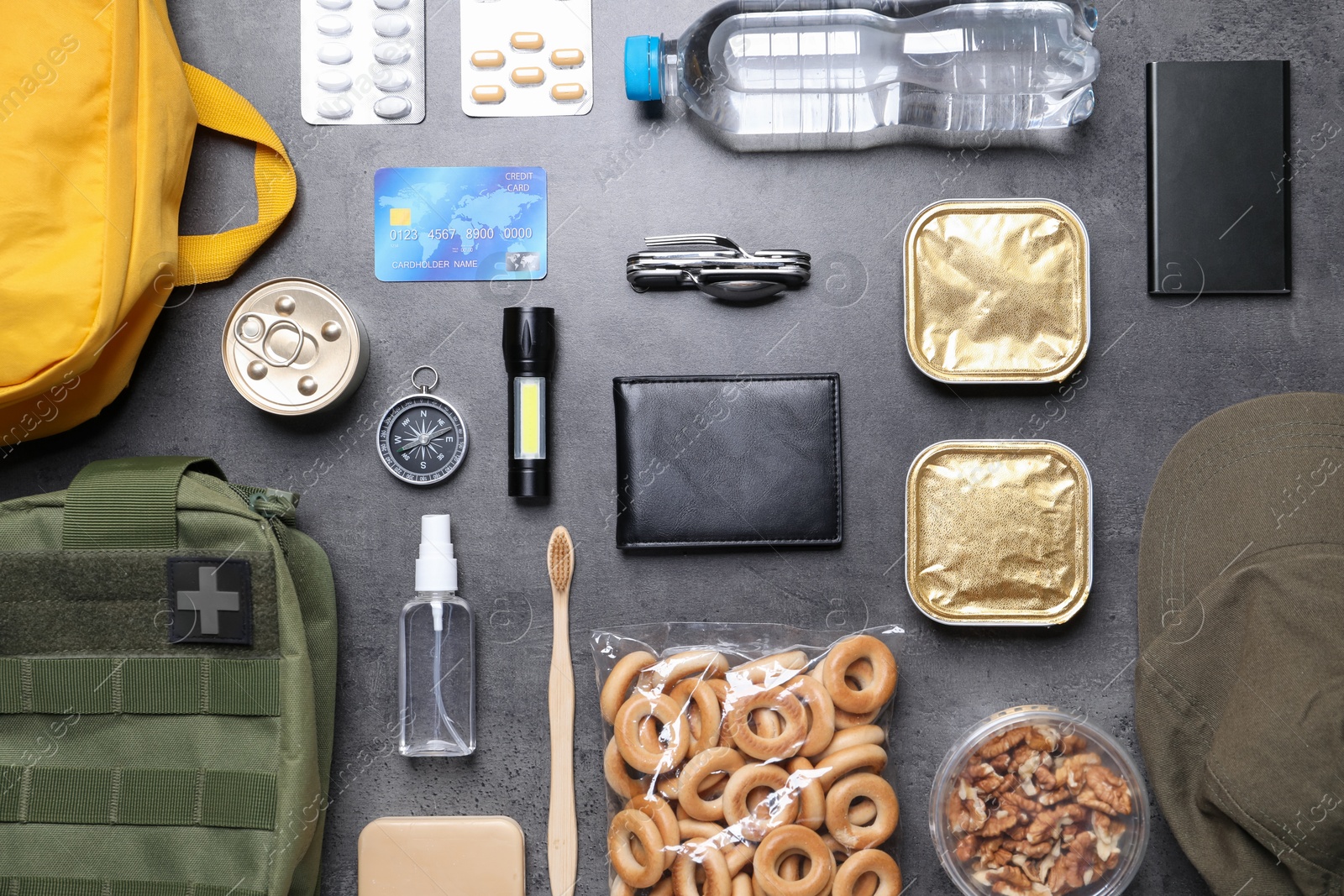 Survival kit. Different emergency supplies on grey table, flat lay Photo of Survival kit. Different emergency supplies on grey table, flat lay