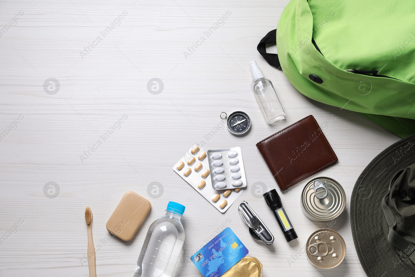 Survival kit. Different emergency supplies on white wooden table, flat lay. Space for text Photo of Survival kit. Different emergency supplies on white wooden table, flat lay. Space for text