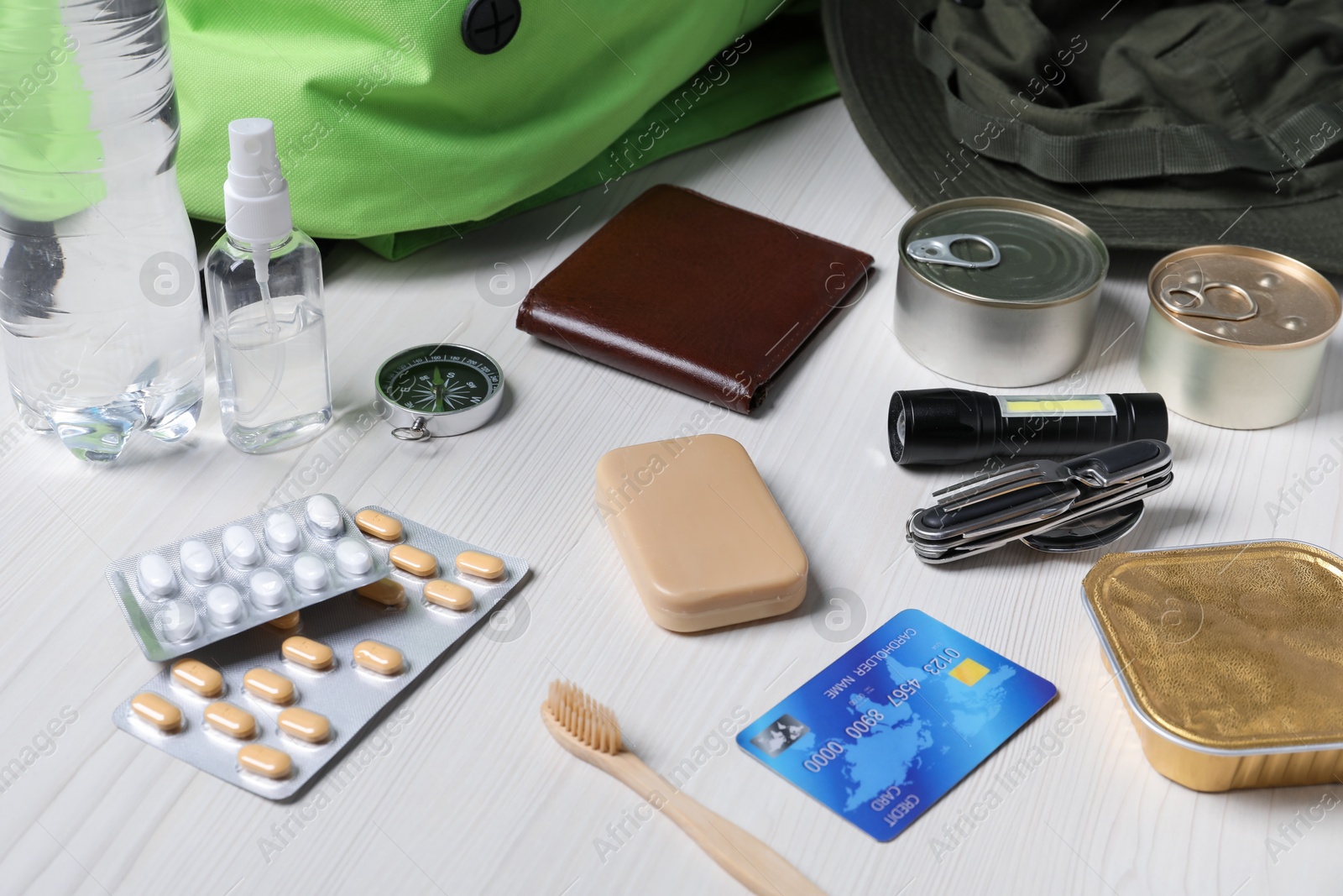 Survival kit. Different emergency supplies on white wooden table, closeup Photo of Survival kit. Different emergency supplies on white wooden table, closeup