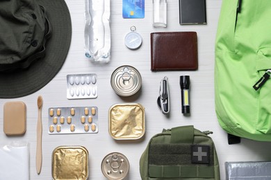 Photo of Survival kit. Different emergency supplies on white wooden table, flat lay