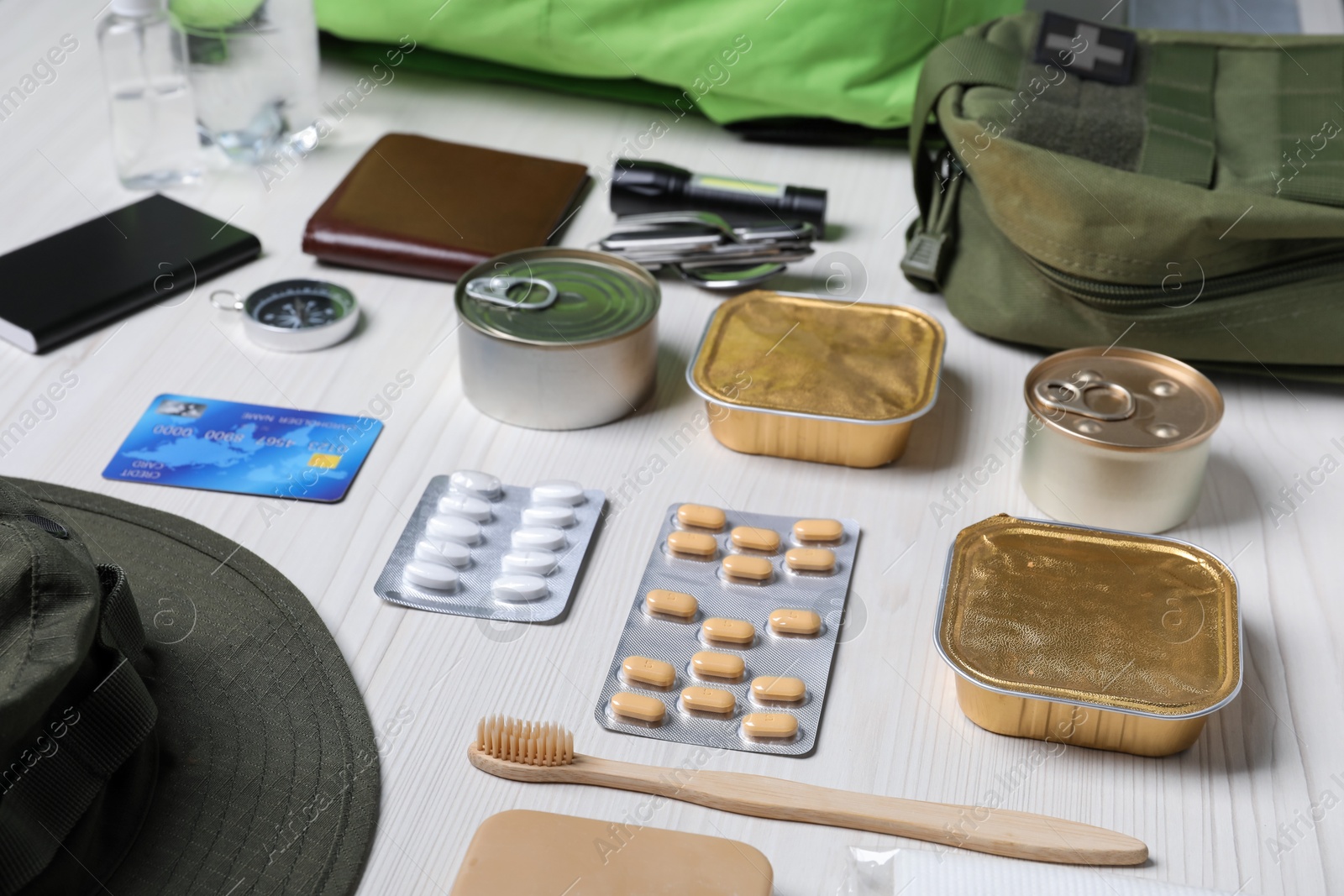 Survival kit. Different emergency supplies on white wooden table, closeup Photo of Survival kit. Different emergency supplies on white wooden table, closeup