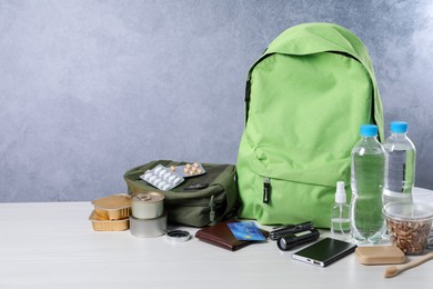 Photo of Survival kit. Different emergency supplies on white wooden table, space for text