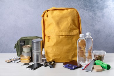 Photo of Survival kit. Different emergency supplies on white wooden table