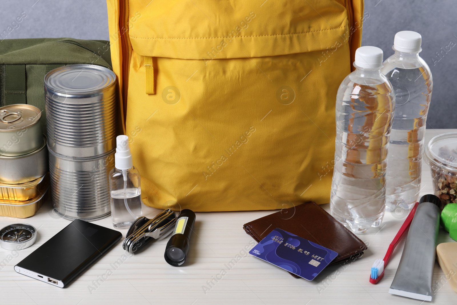 Survival kit. Different emergency supplies on white wooden table, closeup Photo of Survival kit. Different emergency supplies on white wooden table, closeup