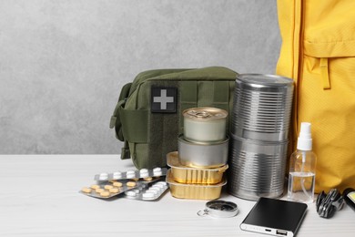 Photo of Survival kit. Different emergency supplies on white wooden table, space for text