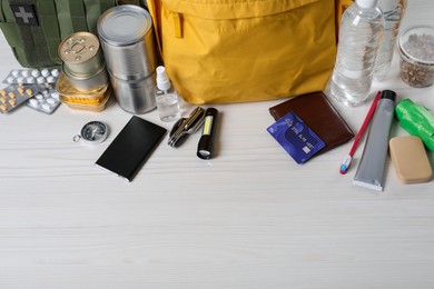 Photo of Survival kit. Different emergency supplies on white wooden table, above view. Space for text