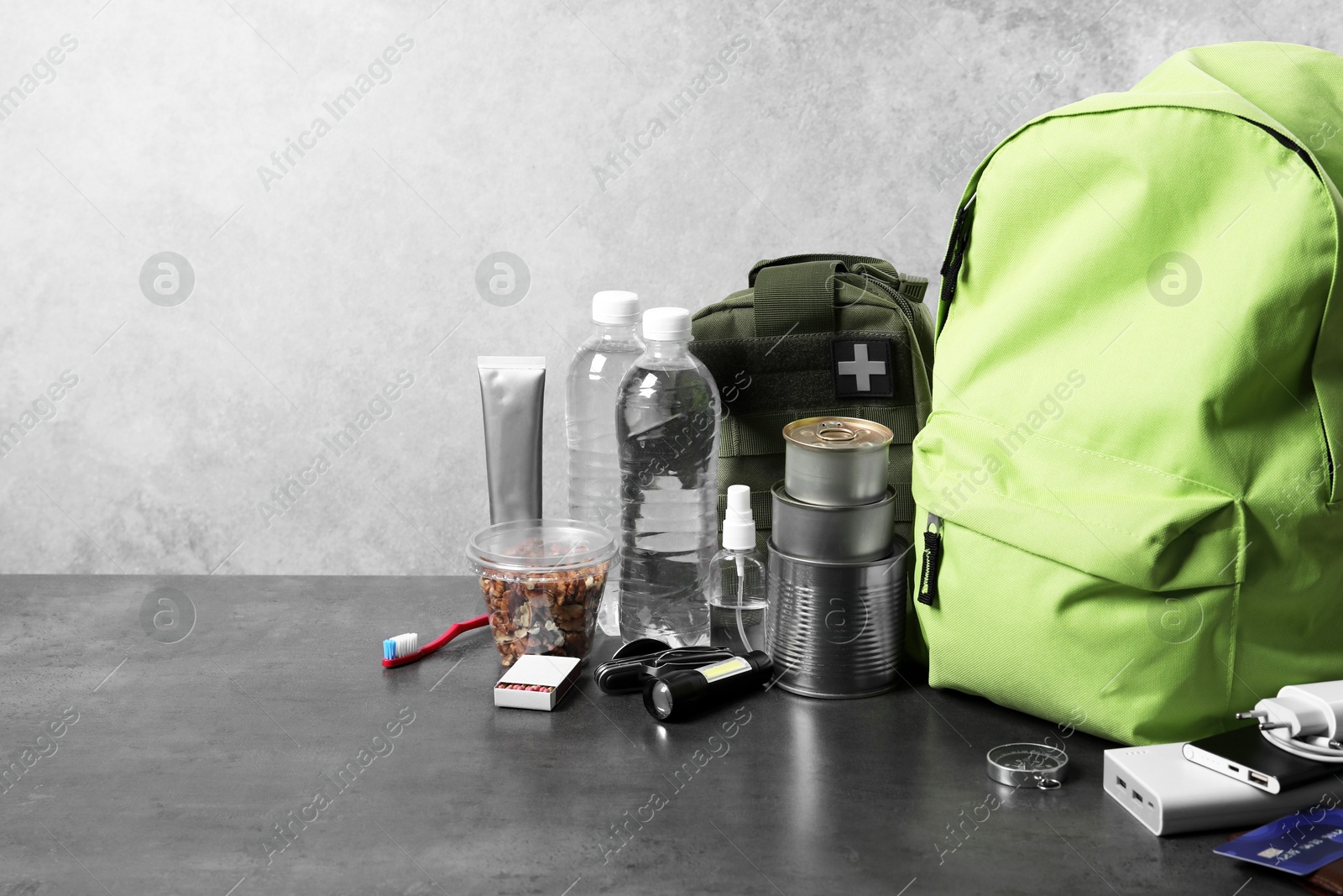 Survival kit. Different emergency supplies on grey table, space for text Photo of Survival kit. Different emergency supplies on grey table, space for text