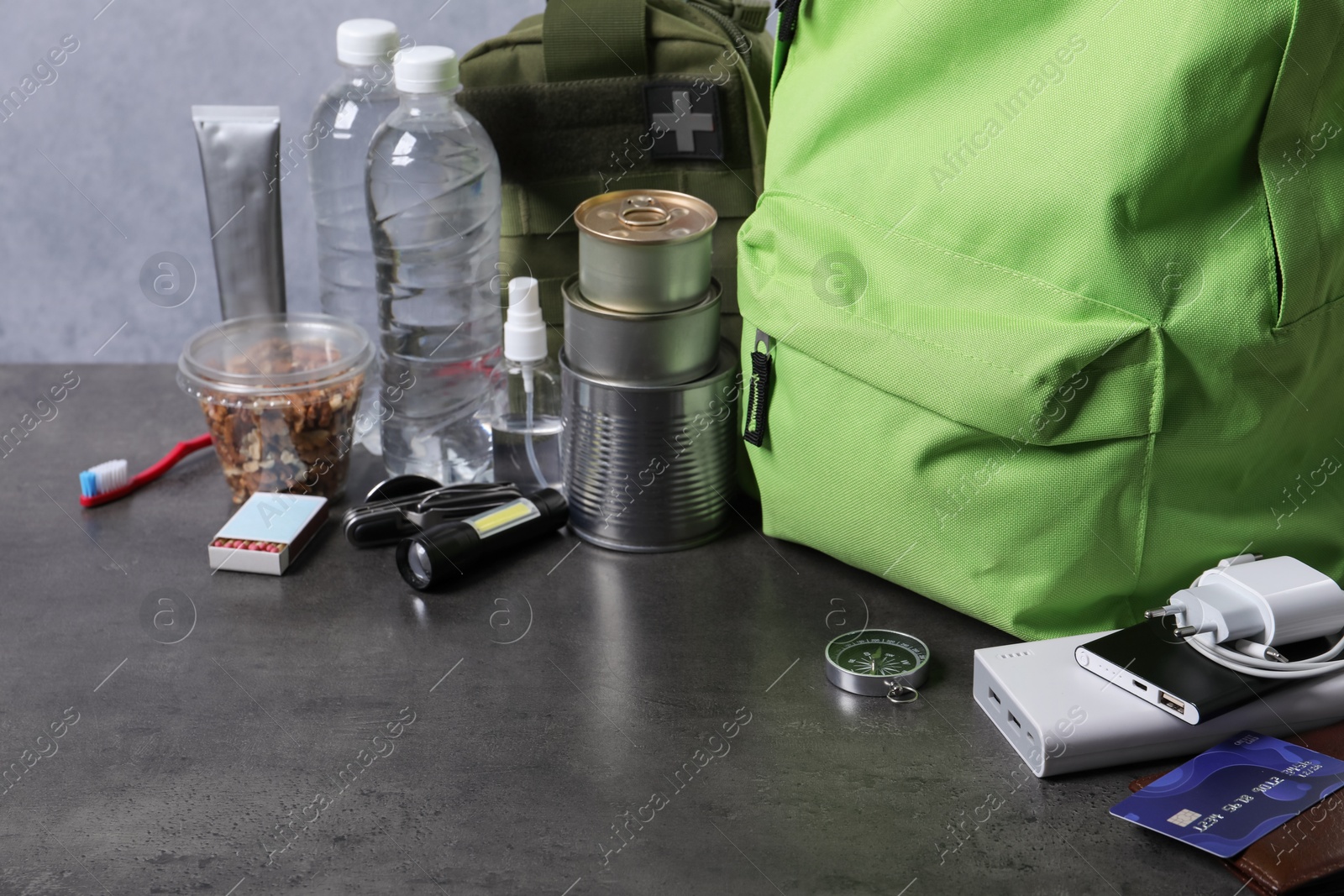 Survival kit. Different emergency supplies on grey table Photo of Survival kit. Different emergency supplies on grey table